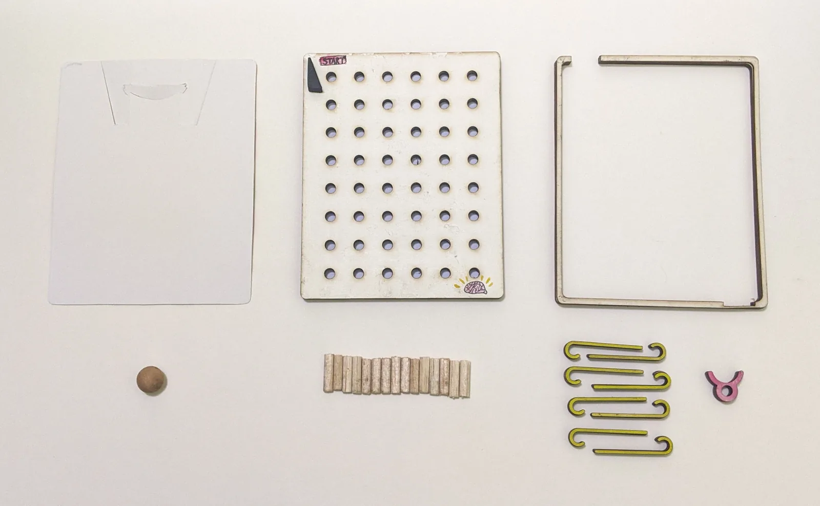 Early maze parts and peg board arranged for testing