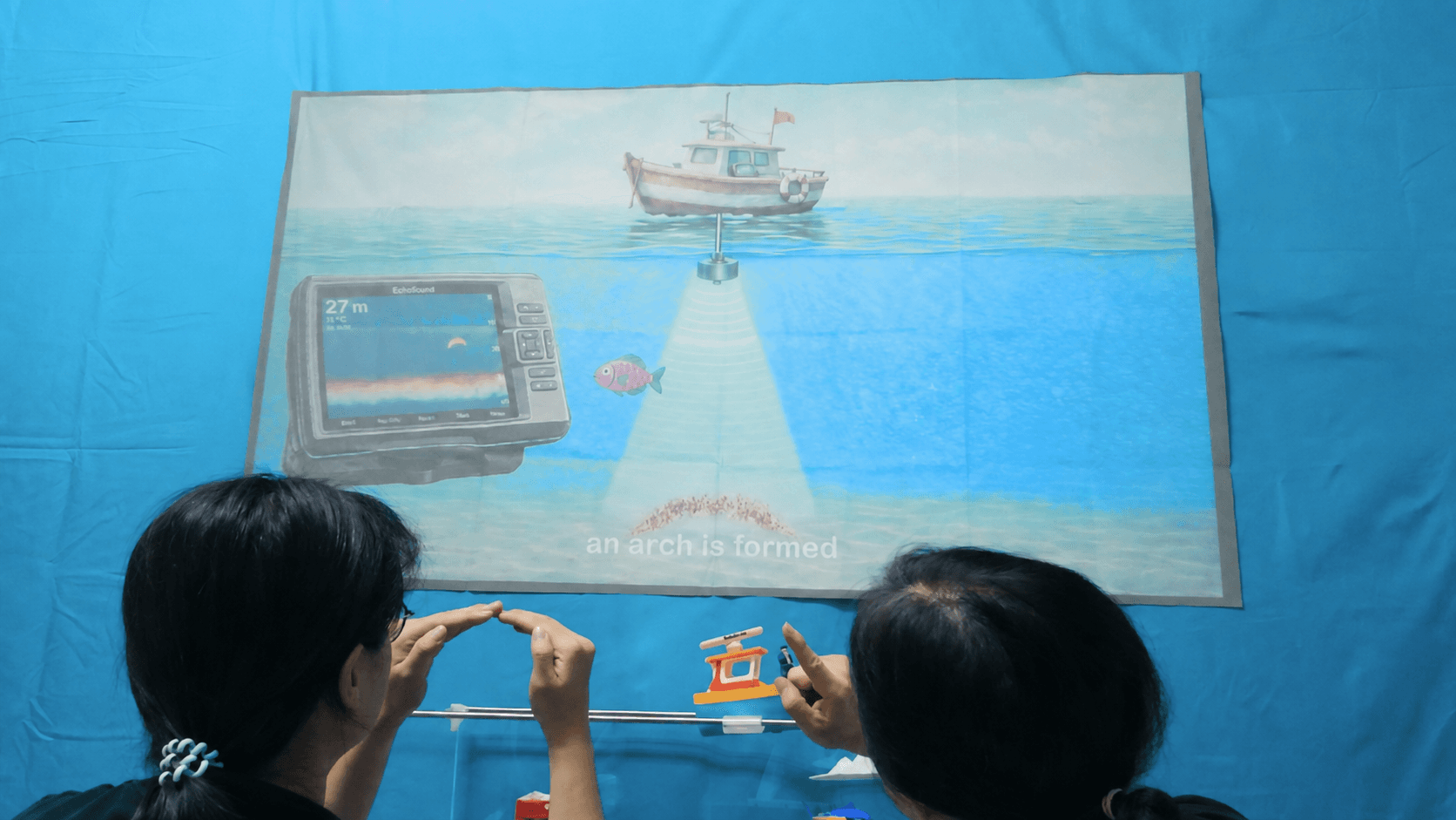 Players watching SONAR 101 to see how echoes reveal the underwater world